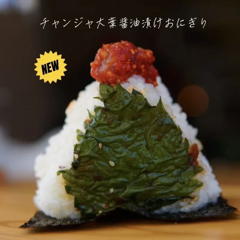 新作のチャンジャ大葉醤油漬けおにぎり。大葉の醤油漬けを添えたおにぎりの上にチャンジャをのせている